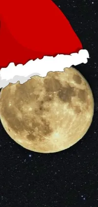 This live phone wallpaper showcases a full moon wearing a festive Santa hat against a starry background