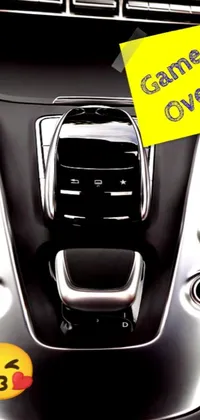Elevate your phone's design with this unique live wallpaper featuring a car dashboard with a smiley face sticker, an album cover, and a miniature sports car