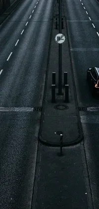 This live wallpaper showcases a vintage car parked along a dark road, adding a postminimalism touch to your phone's display