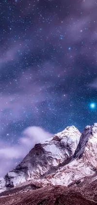 This stunning phone live wallpaper features a serene mountain covered in snow, set against a mesmerizing night sky with a beautiful nebula visible in the background