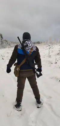 This live wallpaper features a gripping image of a man standing in the snow with a rifle