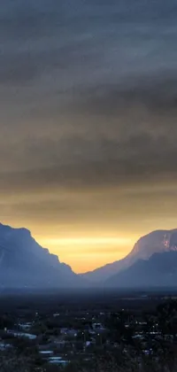 This breathtaking live wallpaper showcases a mountain range under a cloudy sky, perfect for mobile phones
