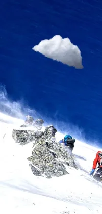 This exhilarating phone live wallpaper features a group of expert skiers who are seen skiing down a snow-covered slope amidst towering clouds in Nepal