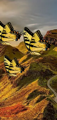 This stunning live phone wallpaper captures a group of realistic butterflies flying over a lush green hillside