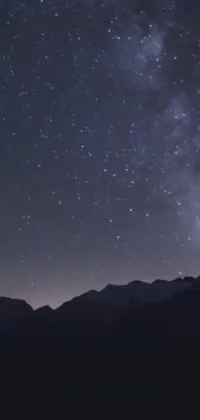 Behold the beauty of the night sky with this stunning live wallpaper, featuring a majestic mountain scape as the backdrop