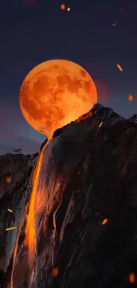 Experience the surreal beauty of a full moon rising over a mountain and hot lava streams with this stunning live phone wallpaper
