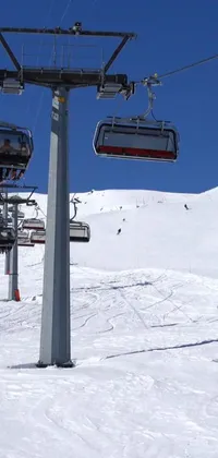 This live phone wallpaper presents a skier riding a ski lift on top of a snow-covered slope, surrounded by gondolas and trams
