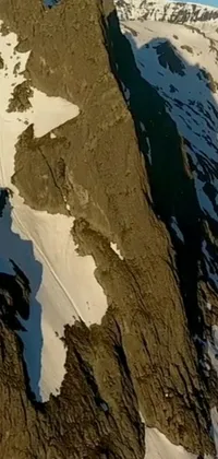 Enjoy the ultimate adrenaline rush with our phone live wallpaper depicting a man soaring through the air on top of a snow covered mountain