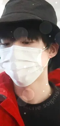 This live wallpaper showcases a close-up of a person sporting a face mask and wearing a red hat