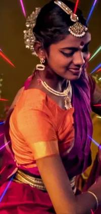 This dynamic phone live wallpaper showcases a captivating dance performance by a woman donning vibrant traditional attire