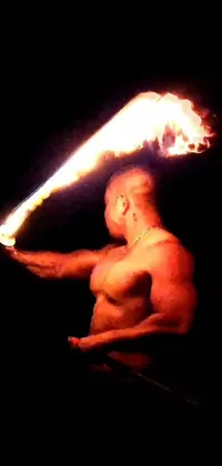 This phone live wallpaper features an awe-inspiring and epic scene, with a muscular man holding a fiery stick and surrounded by a blazing aura