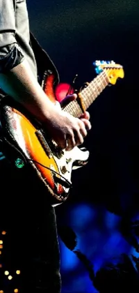 This captivating phone live wallpaper depicts a man playing an electric guitar in front of a crowd, taken in 2012