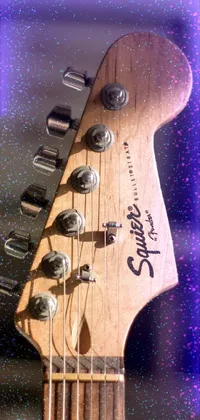 Looking for a phone live wallpaper that showcases your love for music? Look no further than this realistic depiction of a guitar neck, complete with a blurry background, a fender stratocaster, and real guitars hanging on the wall