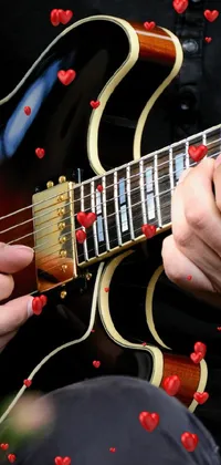 This delightful live wallpaper features a vibrant and captivating close-up image of a guitar being played, with exceptional detail in the textures and intricate movements of the musician's fingers
