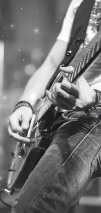 This sleek phone live wallpaper showcases a black and white photo of a guitarist playing at a heavy rock concert