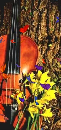 This phone live wallpaper depicts a violin and daffodils beside a tree in a rustic and serene setting