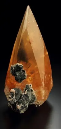 This live wallpaper for your phone laptop presents a stunning rock sitting on a table, adorned with orange minerals