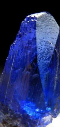 This live phone wallpaper showcases a mesmerizing blue crystal on a black backdrop, emphasizing its natural beauty