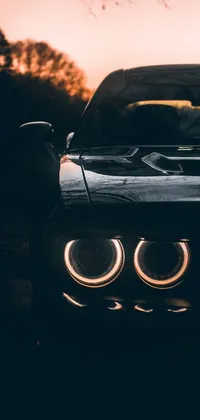 Transform your phone's wallpaper with this stunning black-themed live wallpaper featuring the striking headlights of a muscle car
