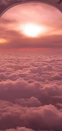 This live wallpaper showcases a breathtaking aerial view of the sky from the viewpoint of an airplane window