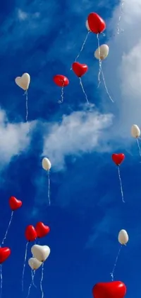 Looking for a fun and romantic live wallpaper for your phone? Check out this beautiful design featuring red and white balloons floating in the air against a serene blue sky