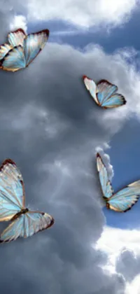 This stunning phone live wallpaper depicts a group of colorful butterflies flying gracefully through a cloudy sky