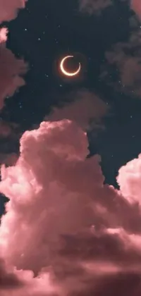This live wallpaper showcases an eclipse in the sky with fluffy clouds in the foreground, radiating a dreamy, magical aesthetic