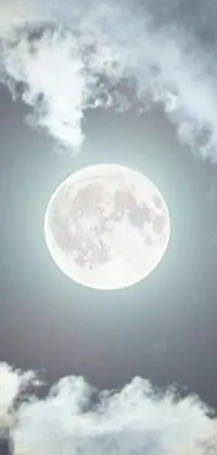 This stunning live phone wallpaper features a full moon in a cloudy sky, surrounded by beautiful patterns of vibrant hurufiyya art