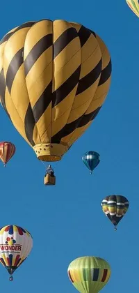 This phone live wallpaper showcases a colorful group of hot air balloons gliding through the clouds