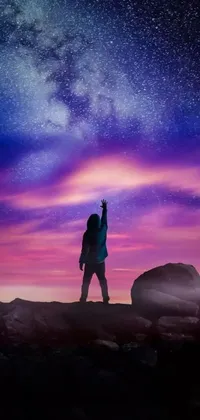 This live phone wallpaper captures a breathtaking digital art of a person standing on a rock under a majestic purple sky filled with stars