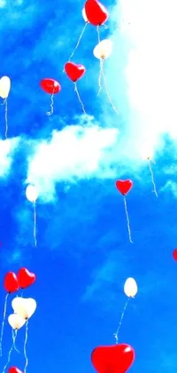 This vibrant phone live wallpaper features a beautiful scene of red and white balloons floating in a bright blue sky, surrounded by floating hearts