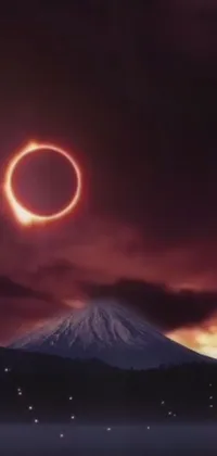Experience the power of nature with this stunning live wallpaper featuring a ring of fire in the sky over a mountain