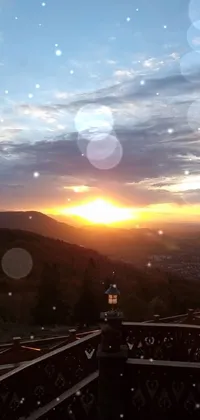 This stunning live wallpaper showcases a breathtaking sunset view from atop a majestic mountain