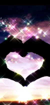 This phone live wallpaper features a heart-shaped hand gesture against a sparkly night sky background