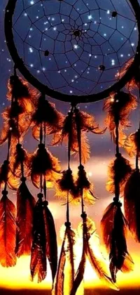 This live wallpaper depicts a digitally rendered dream catcher against a dark orange night sky