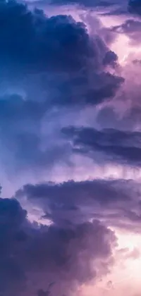 This phone live wallpaper features a stunning image of a plane flying through a cloud-filled sky in shades of purple and blue