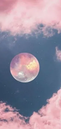 Get lost in a breathtaking live wallpaper of a dreamy pink moon resting on cosmic clouds