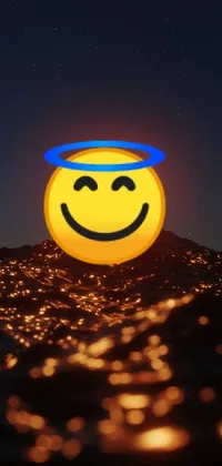 This lively live wallpaper features a grinning yellow face floating above a calm body of water, complete with an angelic halo and a 3D-inspired rendering