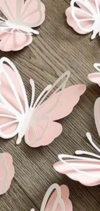 This phone live wallpaper features realistic paper butterflies on a light pink background