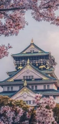 This phone live wallpaper is a stunning Oriental design featuring a majestic Japanese dragon against a backdrop of a large building and pink flowers