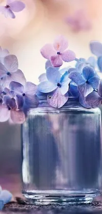 This live wallpaper showcases a glass vase filled with lovely purple and blue flowers, creating a beautifully romantic display on your phone