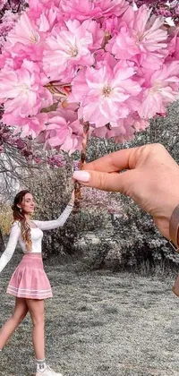This phone live wallpaper showcases a realistic image of a woman holding a bouquet of pink flowers against the backdrop of huge cherry trees