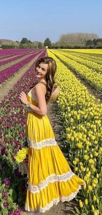 This phone live wallpaper displays a woman wearing a yellow sundress while immersed in a stunning field of tulips