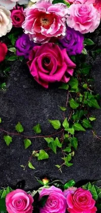 Looking for a romantic and eye-catching live wallpaper to enhance your phone's screen? Look no further as we've got just the thing for you! This digital render by Florianne Becker is a beautiful arrangement of vibrant flowers on a dark rock background, with ivy vines and black and purple rose petals adding a touch of mystery and intrigue