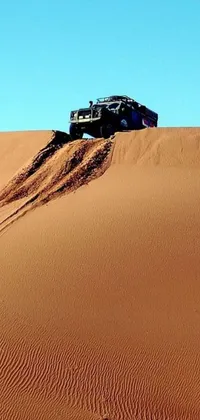 This phone live wallpaper showcases an imposing truck resting on a sandy desert