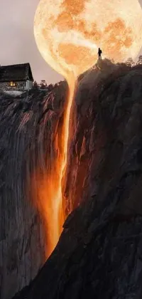 This live wallpaper showcases a stunning digital art piece featuring a man standing atop a cliff beside a waterfall, with a house on a hill in the distance