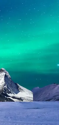 This phone live wallpaper features a stunning mountain landscape covered in snow under a surreal green sky with hints of blue and purple