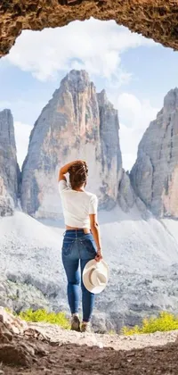 Experience the magical allure of this phone live wallpaper featuring a mysterious woman standing in a vast, dark cave with majestic mountains in the background