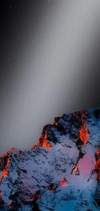 This phone live wallpaper depicts a snow-covered mountain contrasted by flowing lava and molten pieces