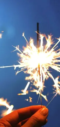This dynamic phone live wallpaper boasts an eye-catching display of a sparkling sparkler in hand